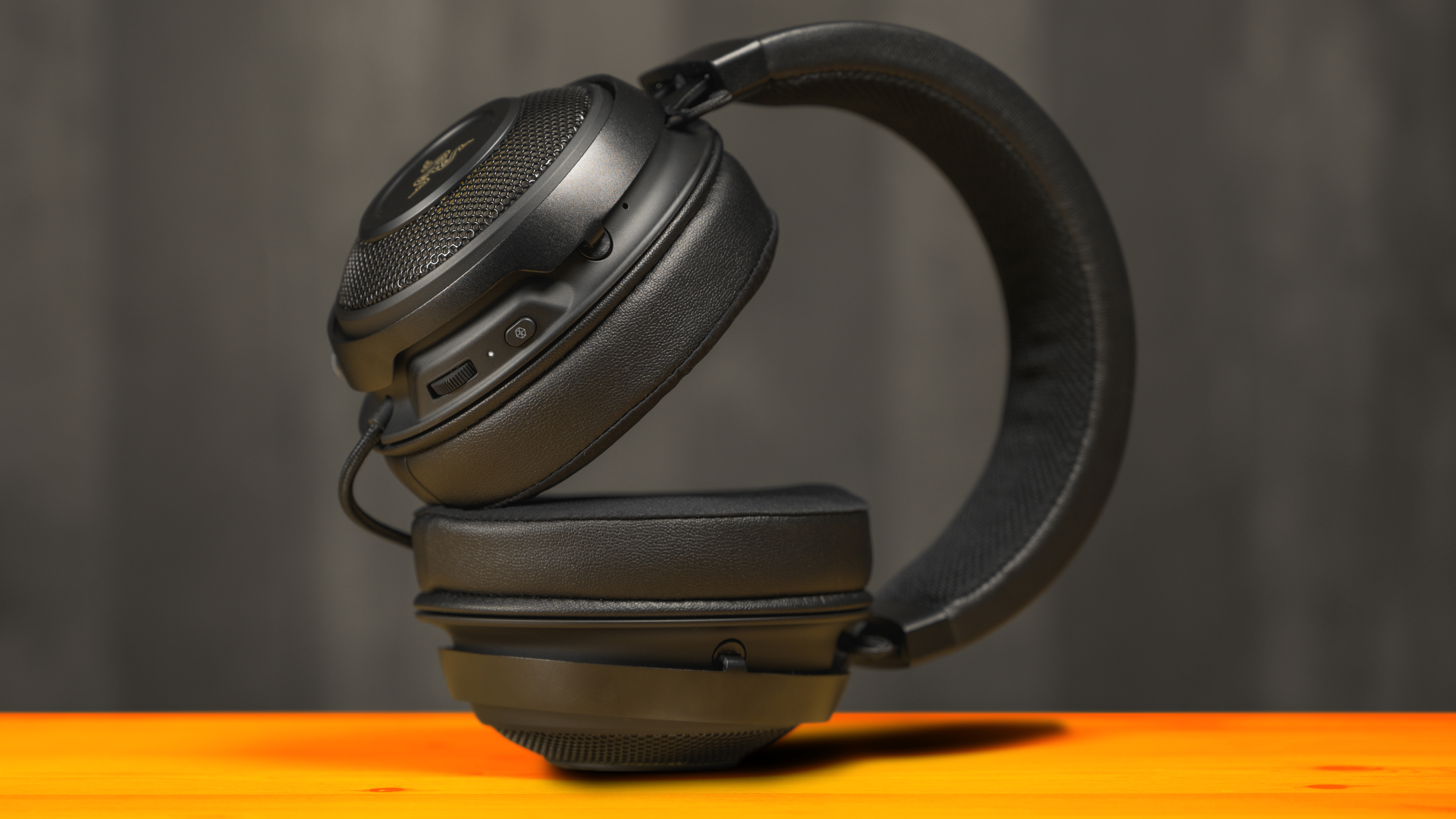 De Razer Kraken Ultimate koptelefoon op zijn zij, met in beeld de on-ear controls op achterzijde van de linker-oorschelp.