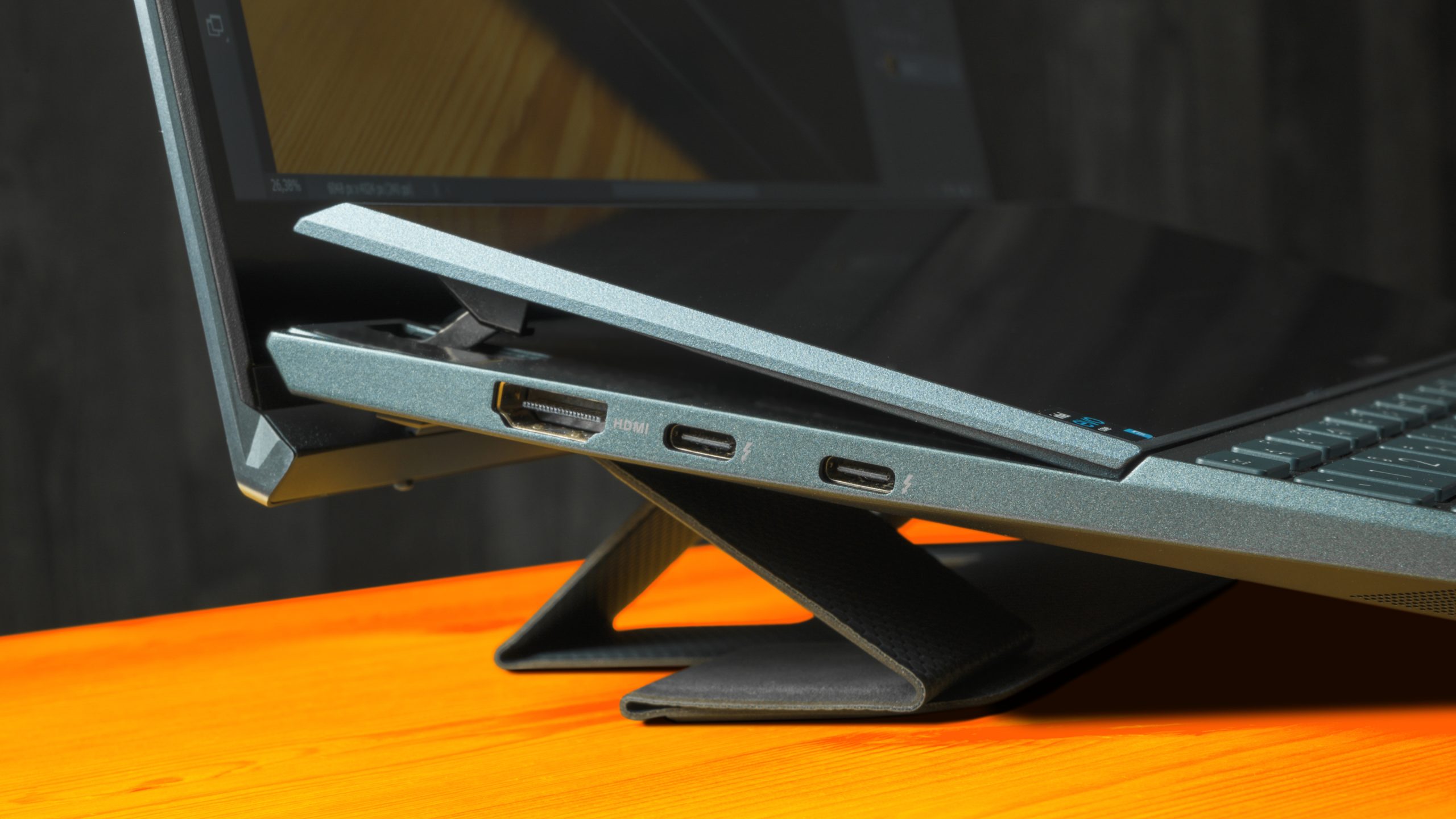 Zijaanzicht van de ASUS ZenBook Duo 14, met het ScreenPad Plus opgeheven uit het chassis en staande op de inbegrepen kickstand.