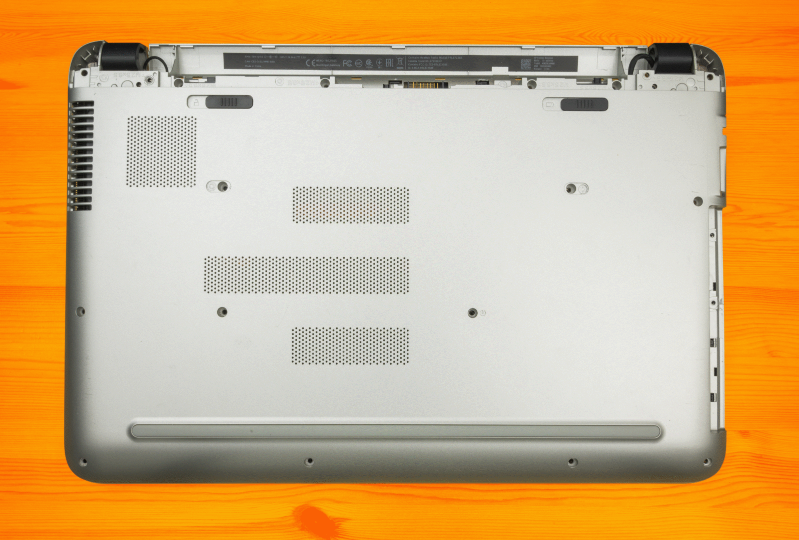 Geanimeerde afbeelding van de achterkant van een notebook, met daaronder allerlei nuttige hardware om los te schroeven.