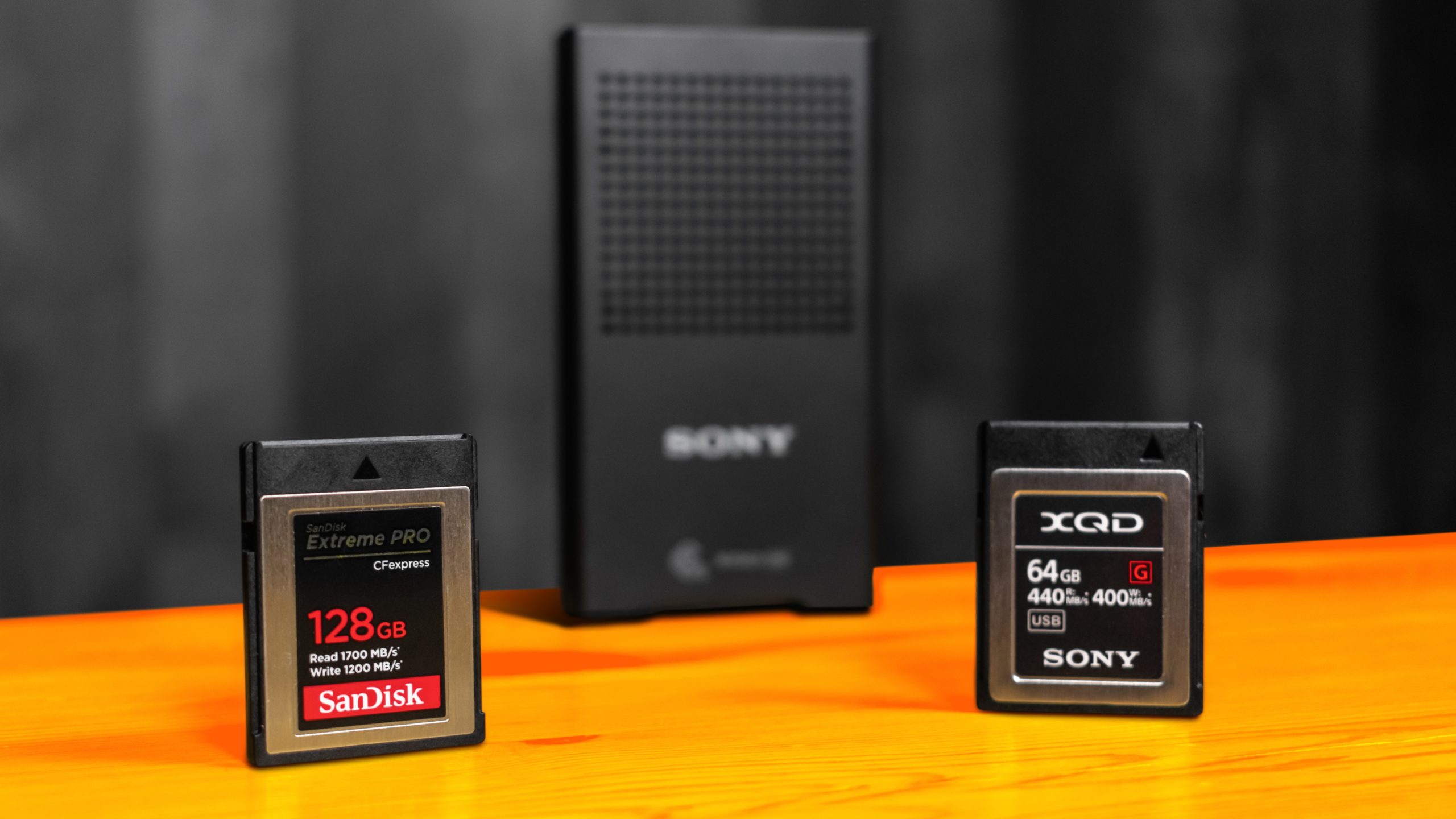Foto van een SanDisk CFExpress Type B-opslagkaart tegenover een XQD-schijf van Sony, beide passen in verscheidenen systeemcamera's en passen in dezelfde kaartlezer.