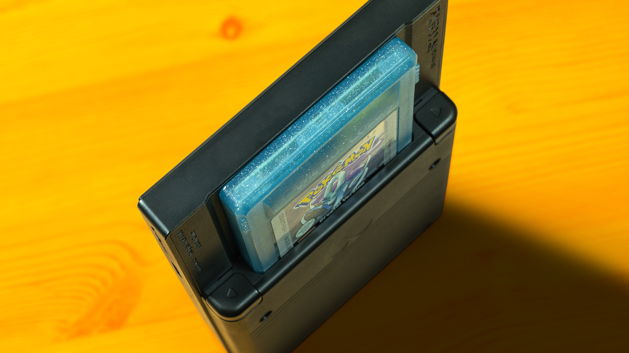 Top-down aanzicht van de Analogue Pocket, met daarin een Pokémon Crystal-cartridge.