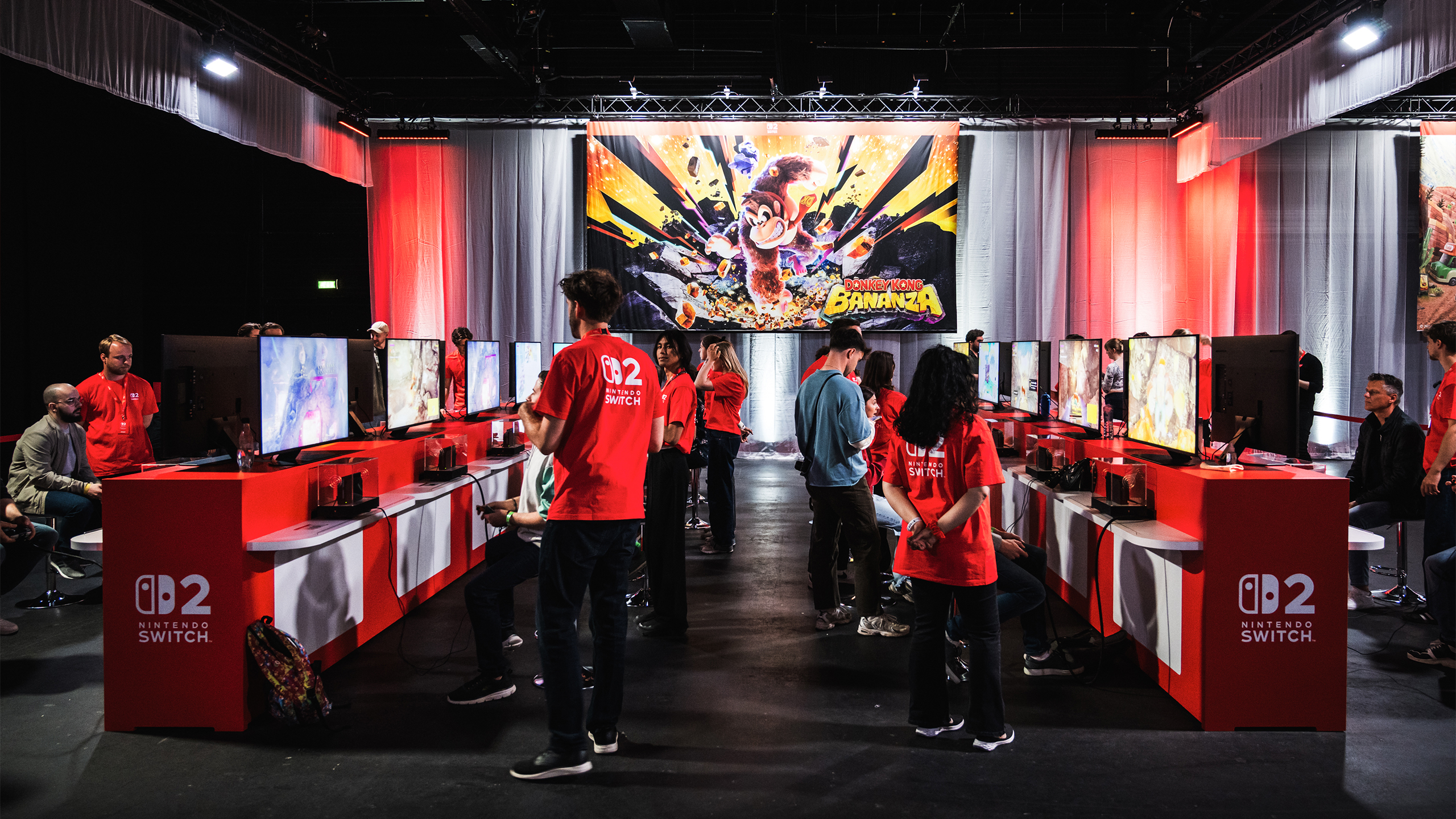 Een rij schermen en set-ups voor Donkey Kong Bananza op het Nintendo Switch 2 Experience-evenement te Zaandam.