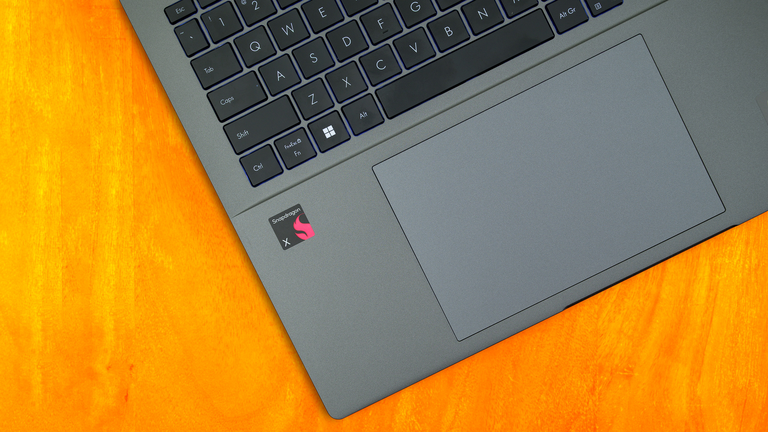 Bovenaanzicht van ASUS' Vivobook 16, met in de linkerhoek duidelijk het Snapdragon X-etiket.