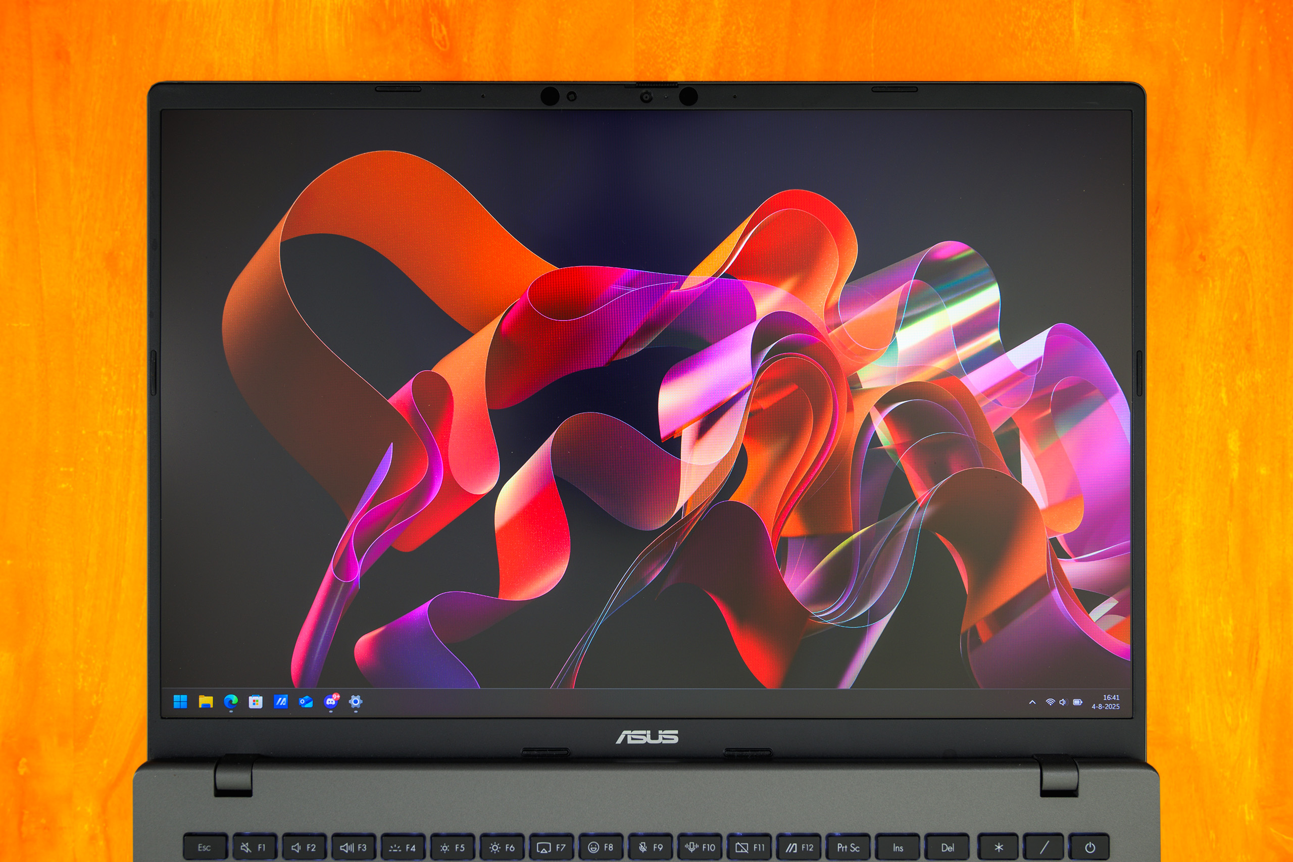 Het 16 inch grote scherm van een ASUS Vivobook, volledig platgelegd op een tafel.