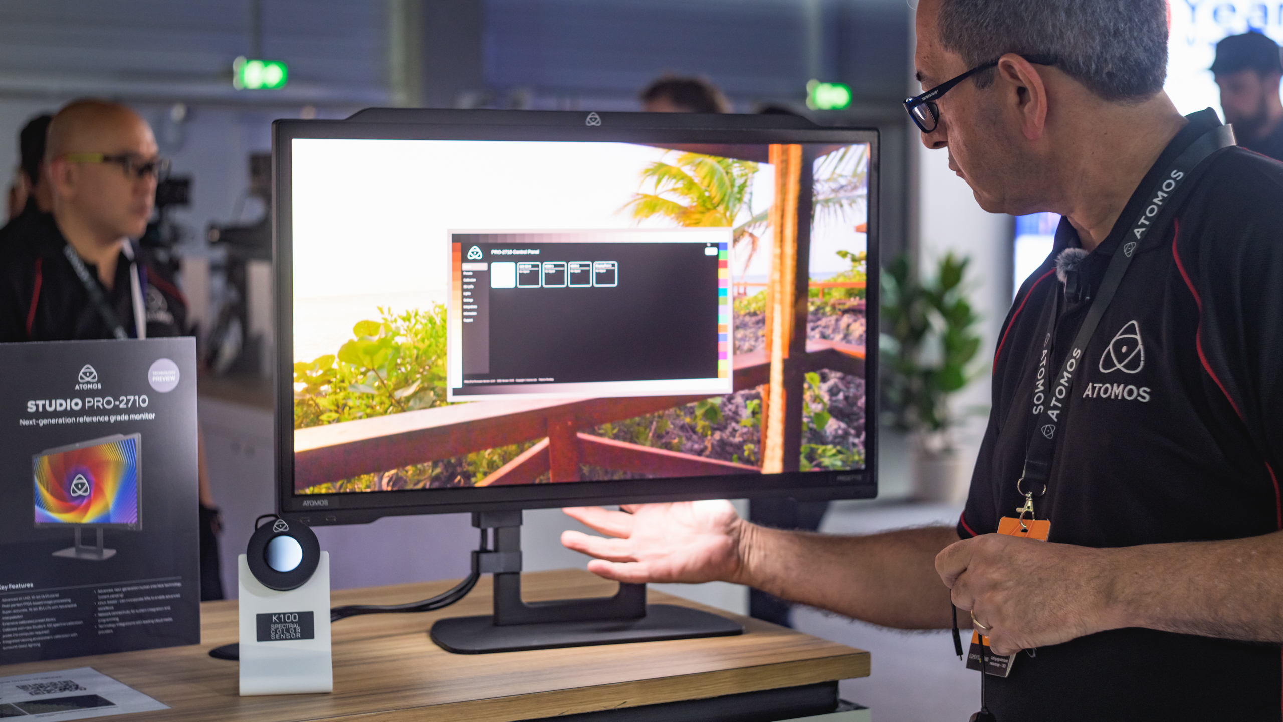Atomos' nieuwe Studio Pro-2710-monitor wordt gedemonstreerd op IBC 2025. Martin Euredjian laat het 'werklicht' onder de monitor duidelijk zien.

Aan de flanken van de monitor is de evenals nieuwe K-100 spectrale kleursensor zichtbaar.
