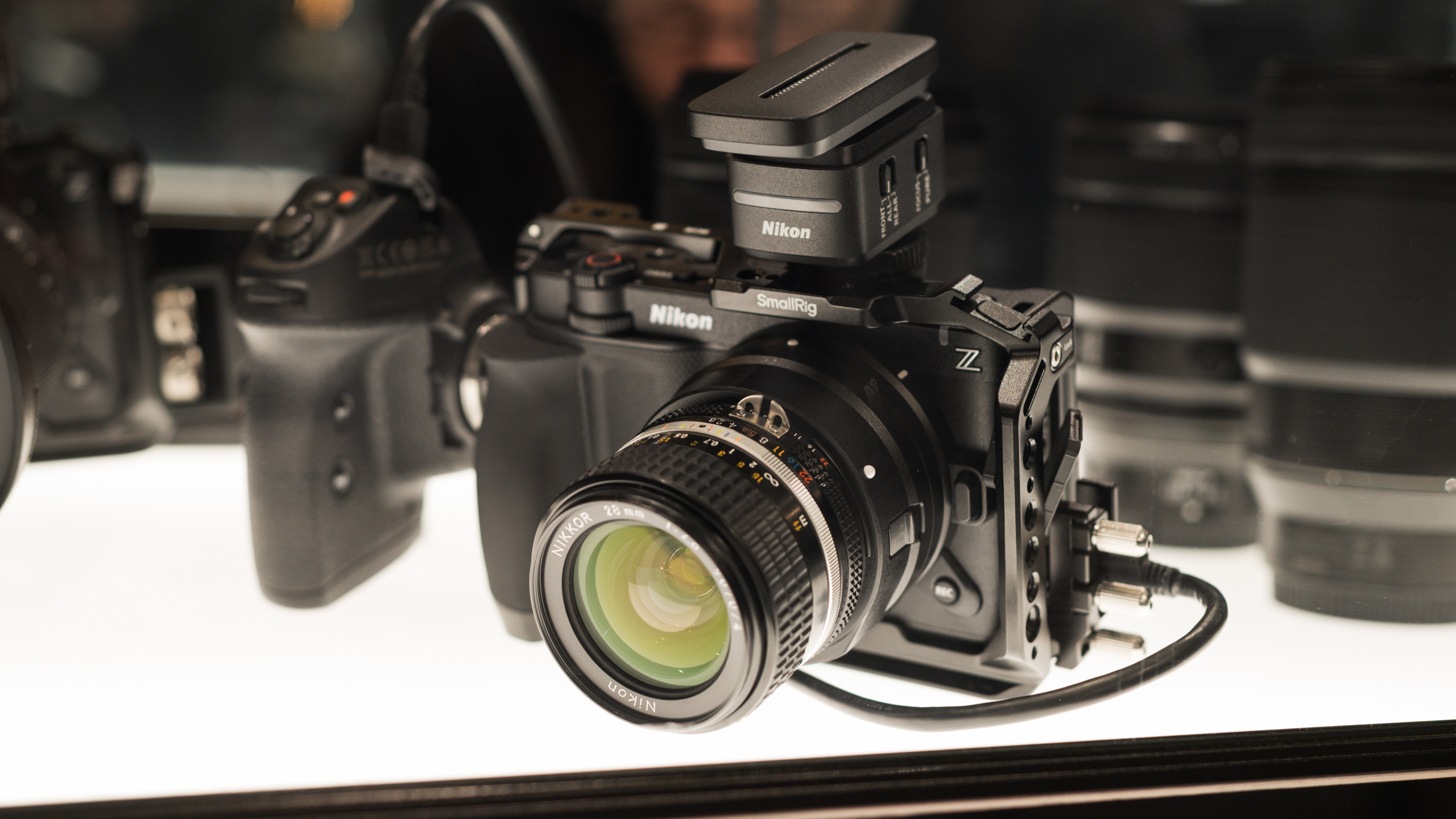 De Nikon ZR wordt tentoongesteld op IBC 2025. In dit geval zit daarop een SmallRig-behuizing, Nikons eigen videogrip, de nieuwe shotgun-microfoon en een analoge F-lens van Nikon.