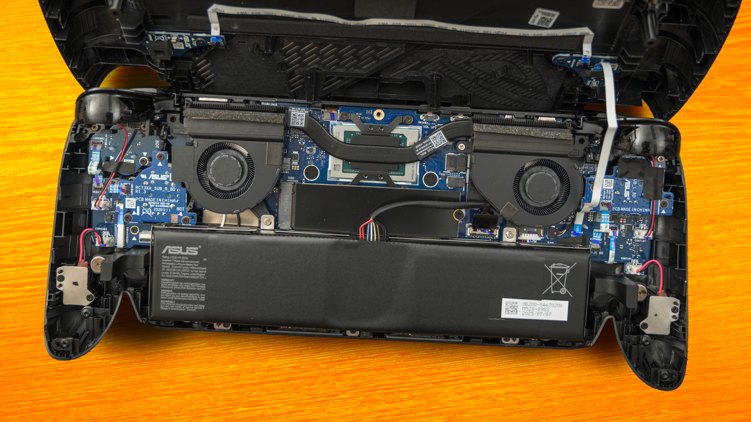 Het binnenwerk van de ROG Xbox Ally X, met daarin duidelijk de 80 wattuur accu en het koelsysteem voor de AMD Ryzen Z2 Extreme zichtbaar.