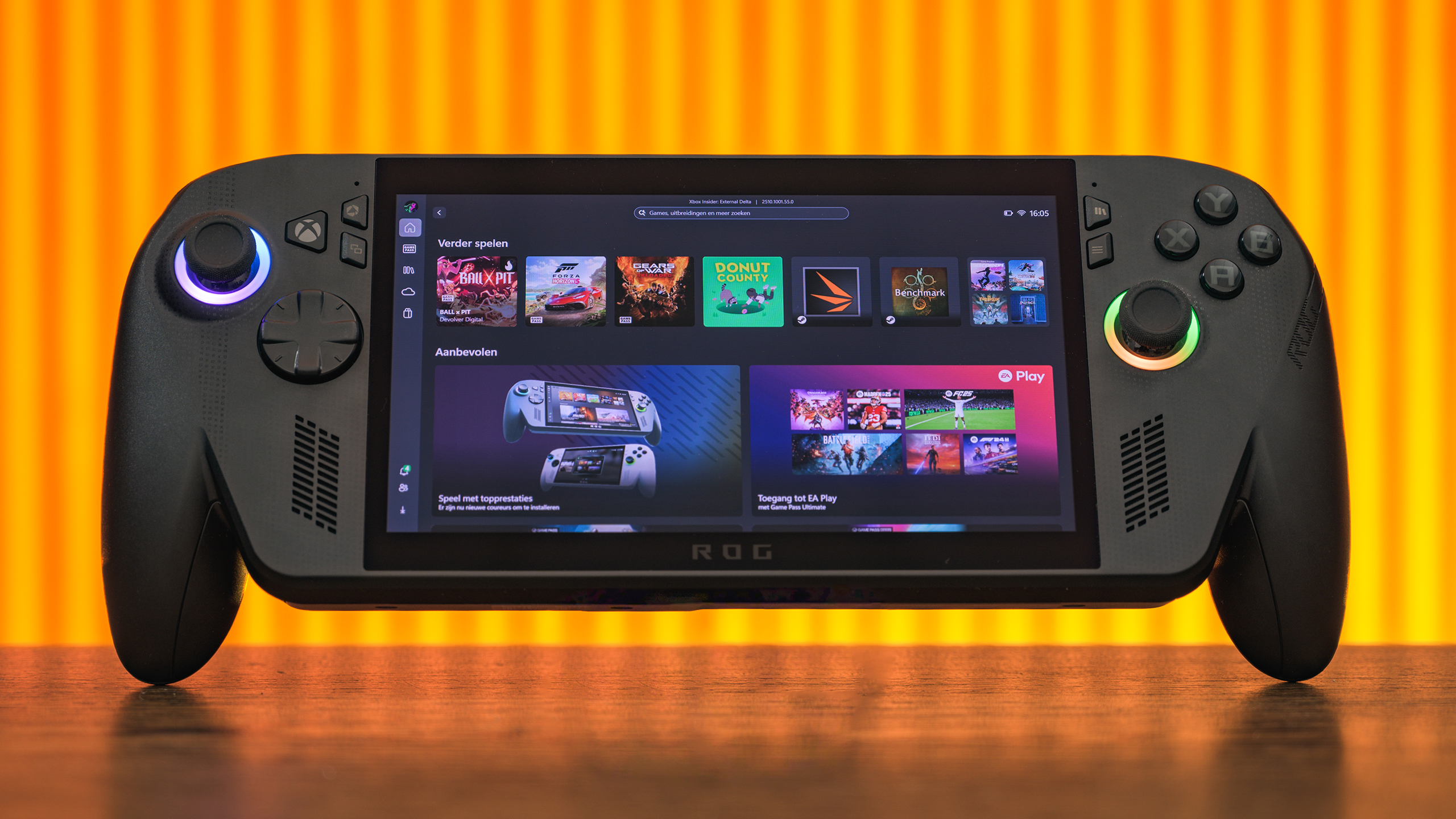 Vooraanzicht van de ROG Xbox Ally X. De handheld staat rechtop, met op de achtergrond een oranje verlichte achtergrond.