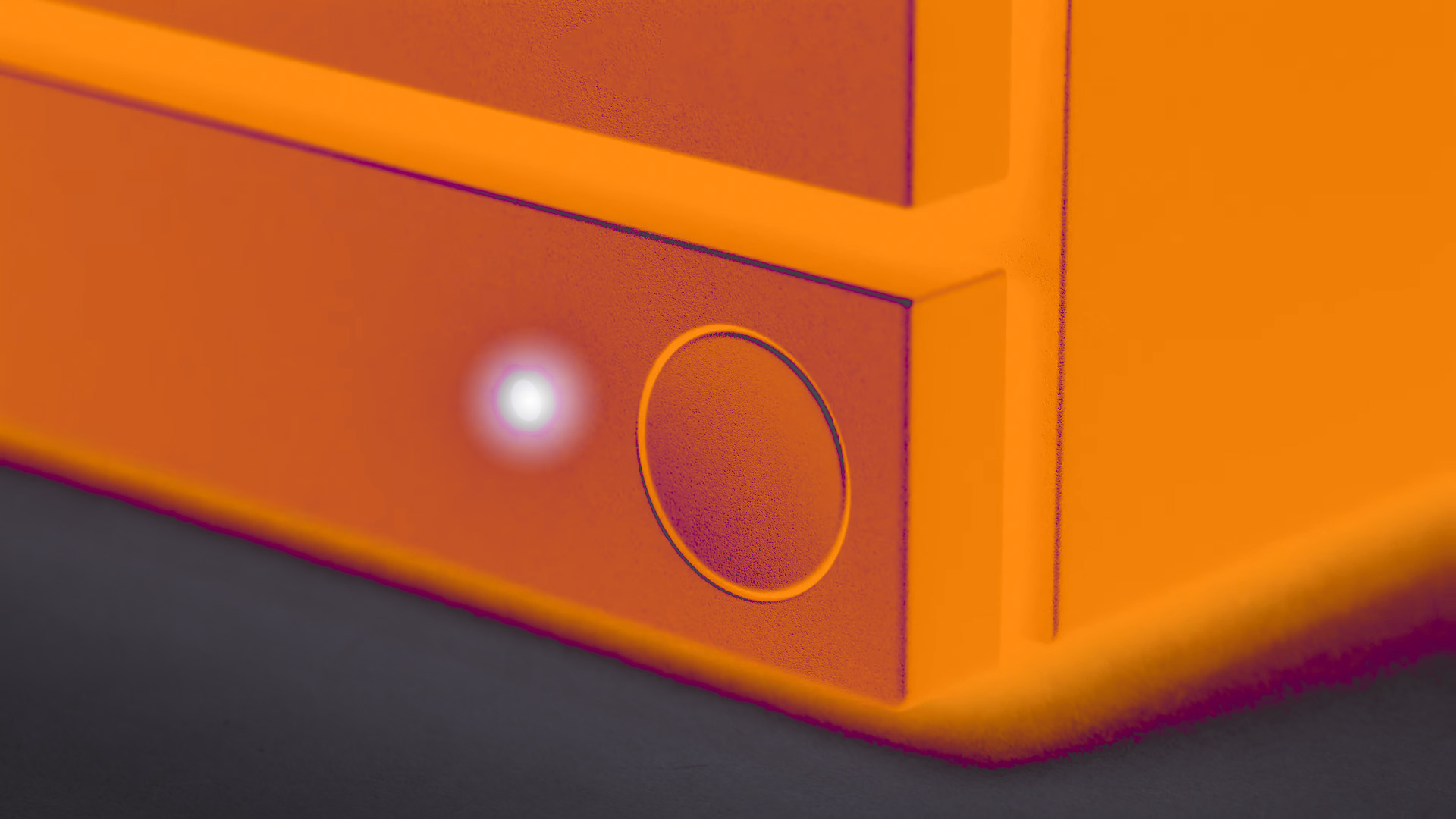 Close-up van de aan/uit-knop van de nieuwe Steam Machine. De foto is bewerkt alsof het apparaat oranje gloeit.