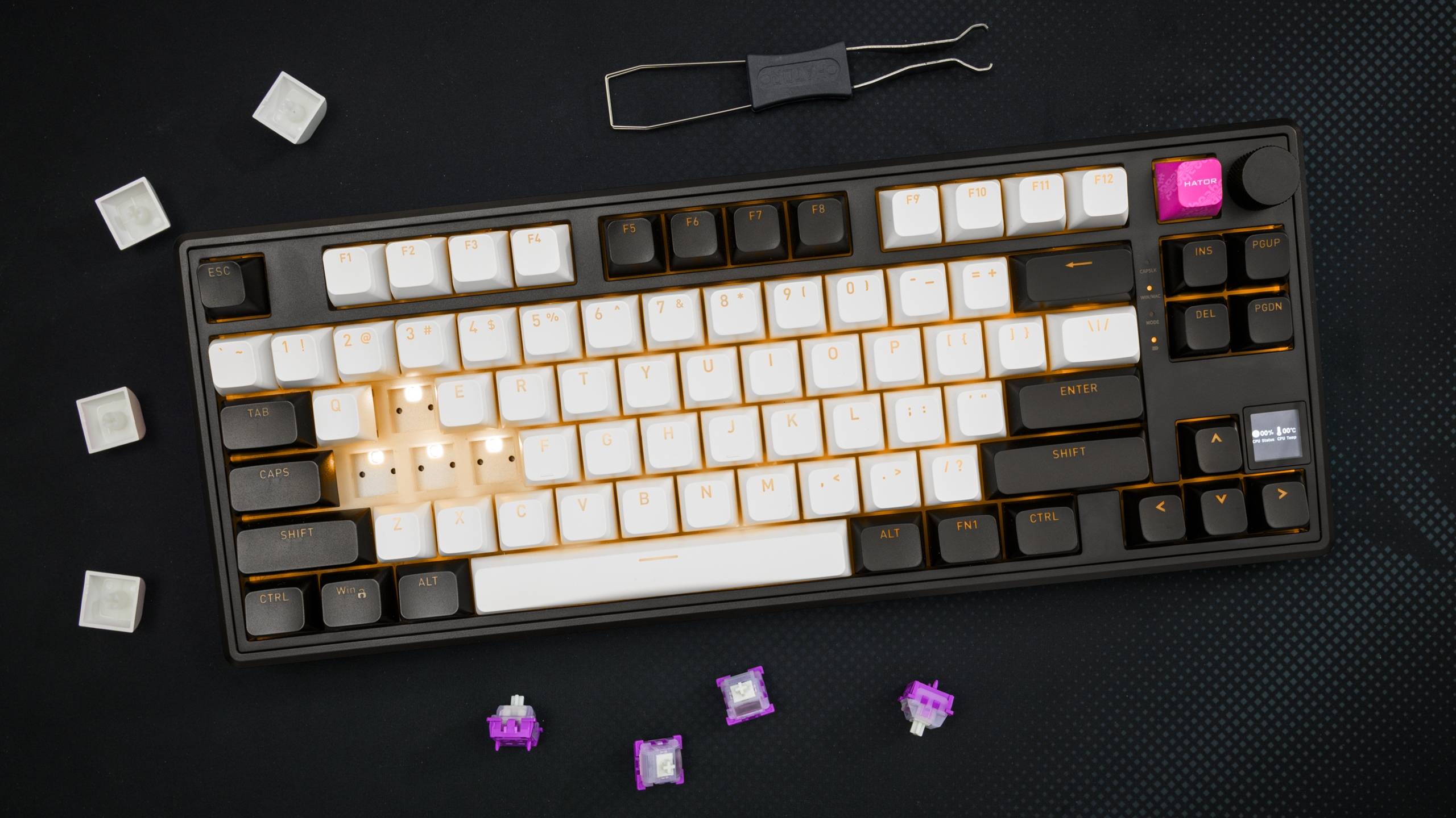 Bovenaanzicht van de Hator Skyfall 80 MAG Ultima 8K, met enkele keycaps en Aurum Ice-switches verwijderd. Die liggen, samen met de keycap-en-switch-puller rondom het toetsenbord, op een grotendeels zwarte deskmat.